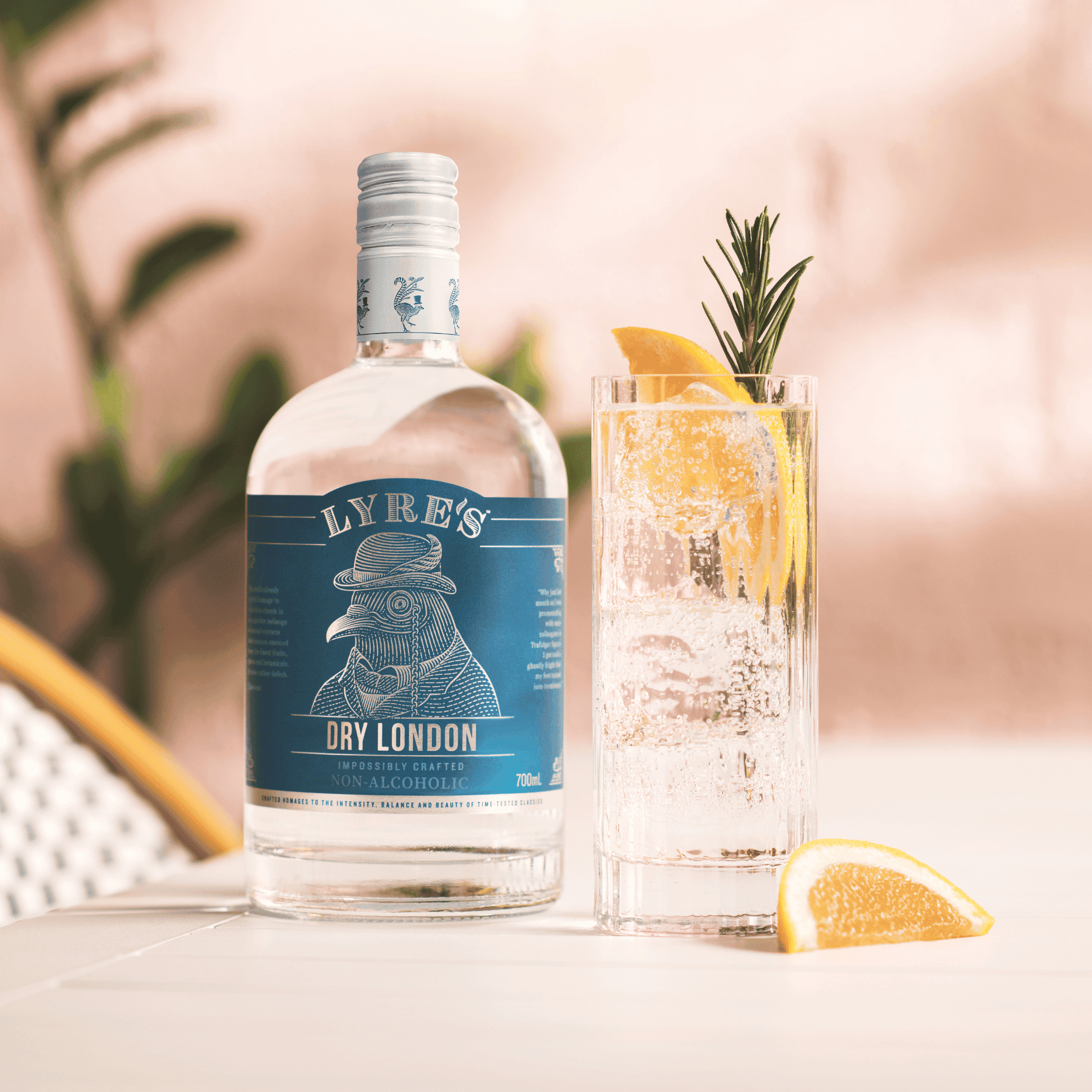 Lyre's Dry London bottle with a cocktail garnished with lemon and rosemary on a blurred outdoor background.