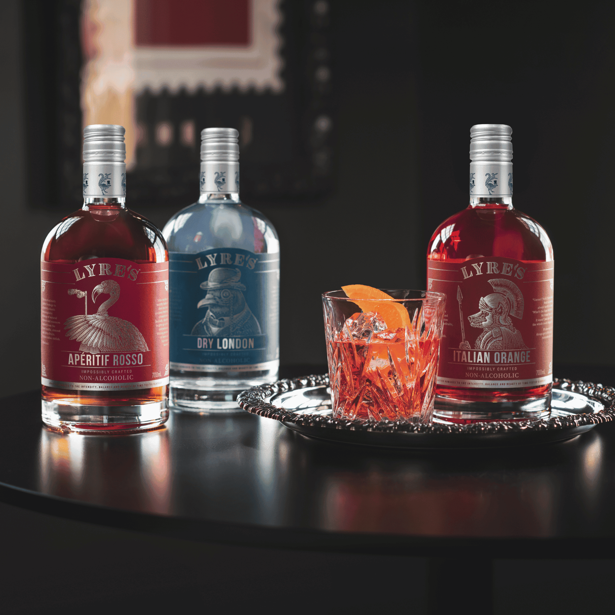 Lyres Dry London, Aperitif Rosso, Italian Orange with a non alcoholic cocktail on a dark surface
